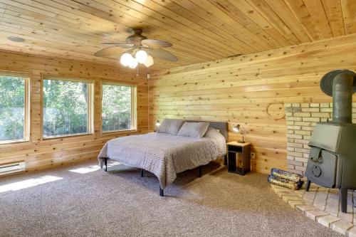 ein Schlafzimmer in einem Blockhaus mit einem Bett und einem Kamin in der Unterkunft Cozy Provo Retreat with a Charming Fireplace! in Provo