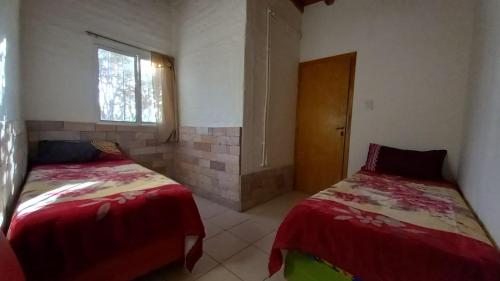 ein Schlafzimmer mit zwei Betten und einem Fenster in der Unterkunft Melen in Maipú