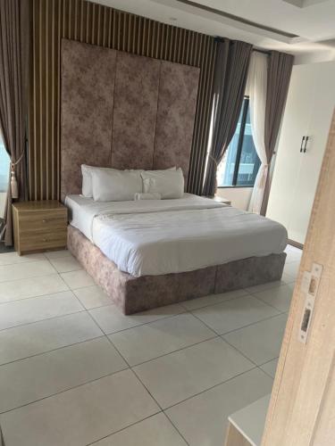 a bedroom with a large bed and a large window at 2 Bedroom Penthouse, Victoria Island Lagos in Maroko