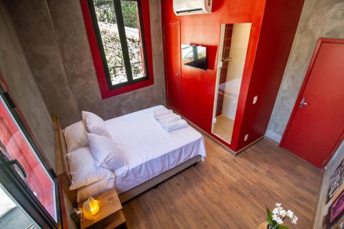 a small bedroom with a bed and a mirror at Lobie Armazém São Joaquim in Rio de Janeiro