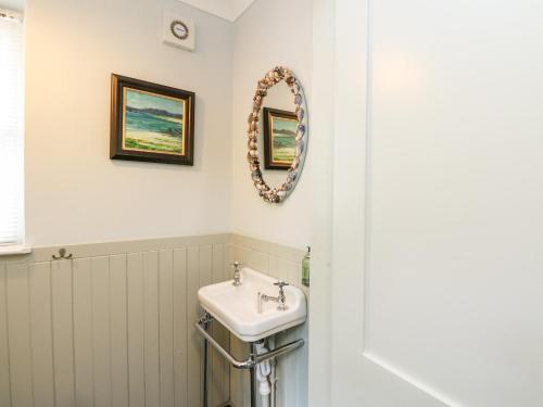 baño con lavabo y espejo en la pared en Fearnach Bay House en Oban