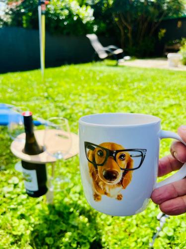 a person holding a cup with a dog face on it at Ferienhaus Sausalblick in Großklein
