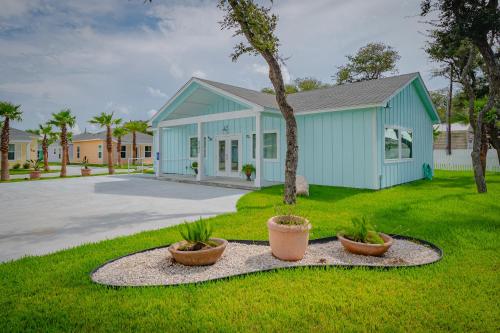 a blue house with two potted plants in front of it at The Oasis Resort in Rockport
