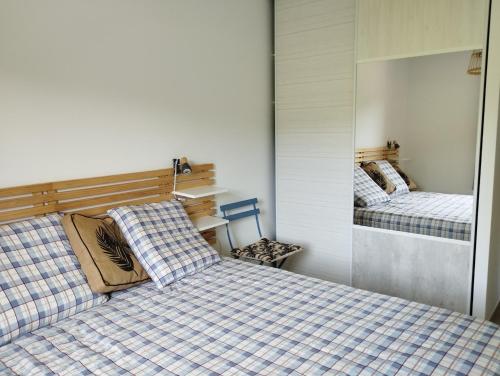- une chambre avec 2 lits et un miroir dans l'établissement Le Martouret, à La Chapelle-en-Vercors