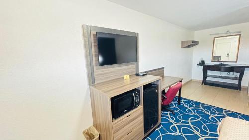 a room with a flat screen tv on a wooden entertainment center at Budget Inn Pecos in Pecos