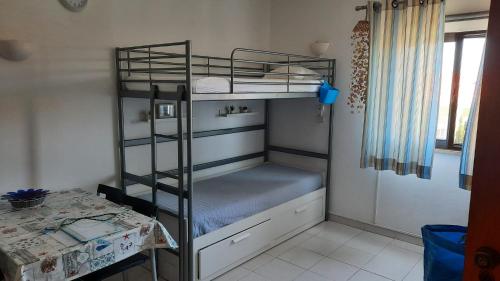 a room with a bunk bed with a table and a tableablish at Nora Velha T0+1 em Tavira in Tavira
