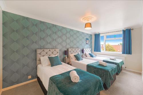 1 dormitorio con 3 camas y ventana en 10% discount on long stays en Chigwell