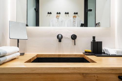 a bathroom with a sink and a mirror at Legato Spa Suites in Naxos Chora
