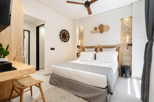 a bedroom with a large bed and a desk at Legato Spa Suites in Naxos Chora