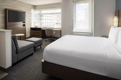 a hotel room with a white bed and a desk at Residence Inn by Marriott Oakland Downtown in Oakland