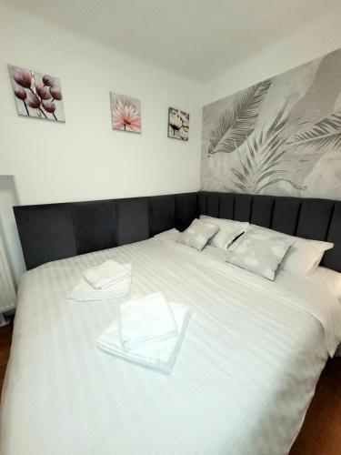 uma grande cama branca com duas toalhas brancas em Pacha Residence em Timisoara