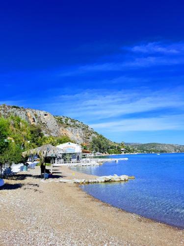 a beach with a rocky shore next to the water at ARETI in Nafplio
