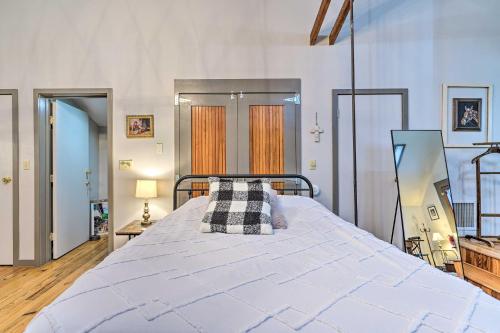 ein großes weißes Bett in einem Zimmer mit zwei Fenstern in der Unterkunft Pet-Friendly Loft Vacation Rental with Fire Pit! in Bemus Point