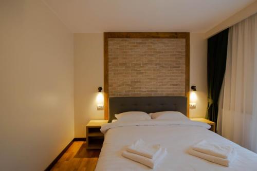 a bedroom with a large white bed with two pillows at Berghaus Bucovina in Câmpulung Moldovenesc