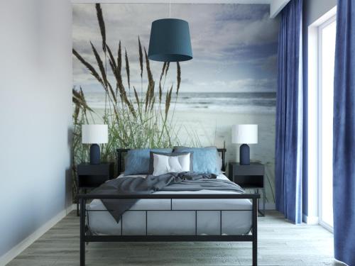 a bedroom with a bed with a painting of the ocean at Stacja Baltic Twins in Sztutowo