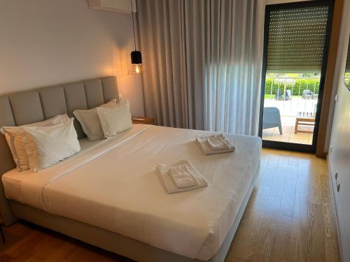 a bedroom with a large bed with two napkins on it at Paraíso da Ria Formosa in Faro