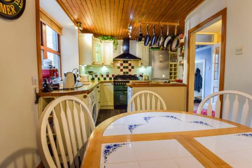 Il comprend une cuisine équipée d'une table, de chaises et d'une cuisinière. dans l'établissement Centre Lodge, à Lerwick
