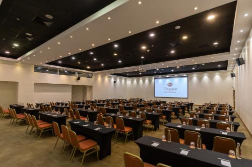 a large room with tables and chairs and a screen at Best Western Premier Marina Las Condes in Santiago