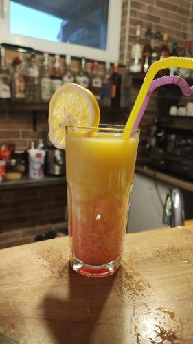 a drink sitting on a table with a lemon slice at Villa Natali in Ohrid