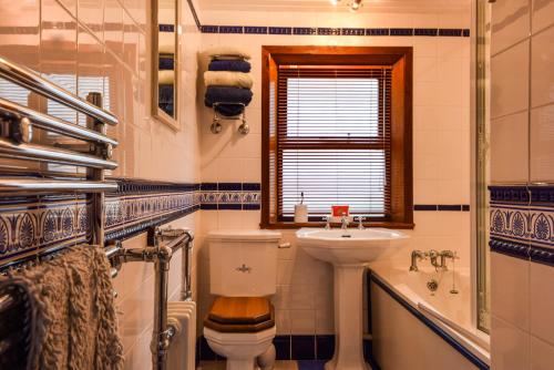 La salle de bains est pourvue de toilettes, d'un lavabo et d'une baignoire. dans l'établissement Centre Lodge, à Lerwick