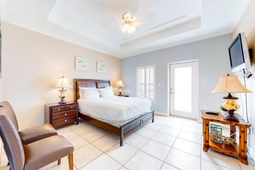 a bedroom with a bed and a chair at Garden Breeze Condominiums #3 in South Padre Island