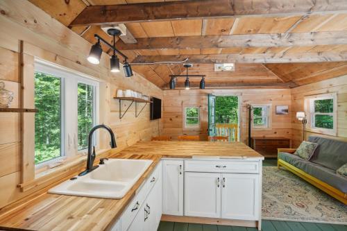 a kitchen with a sink in a tiny house at Gloversville Retreat with Patio and Lake Access! in Gloversville