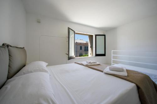 une chambre blanche avec un grand lit et deux fenêtres dans l'établissement Scudaniglio Apartments, à Trapani