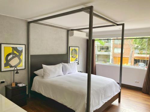 a bedroom with a bed with a four post canopy at Luxury 2BR in Blas Cerdeña San Isidro in Lima