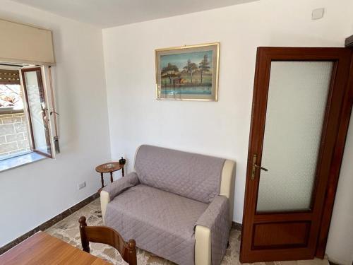 ein Wohnzimmer mit einem Sofa neben einer Tür in der Unterkunft La terrazza sui Nebrodi in Mistretta