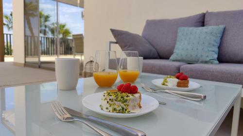 un tavolo con due piatti di cibo e due bicchieri di succo d'arancia di PARADISE premium apartment a Villajoyosa