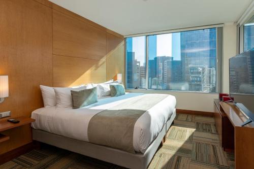 a bedroom with a large bed and a large window at Best Western Premier Marina Las Condes in Santiago