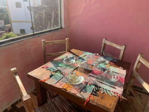 a wooden table with glass dishes on top of it at Pouso nossa senhora das merces in Tiradentes