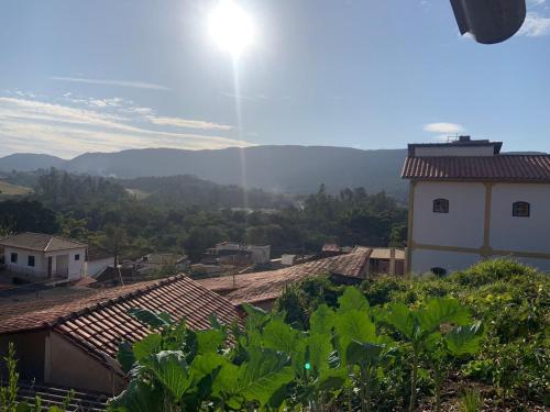 een uitzicht op een dorp met de zon in de lucht bij Pouso nossa senhora das merces in Tiradentes