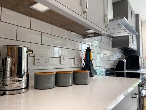 a kitchen with three trash cans on a counter at Superb townhouse near vibrant Gloucester Road in Bristol