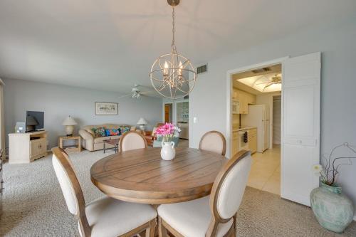 a dining room and living room with a wooden table and chairs at Marco Island Condo with Ocean Views and Resort Perks! in Marco Island
