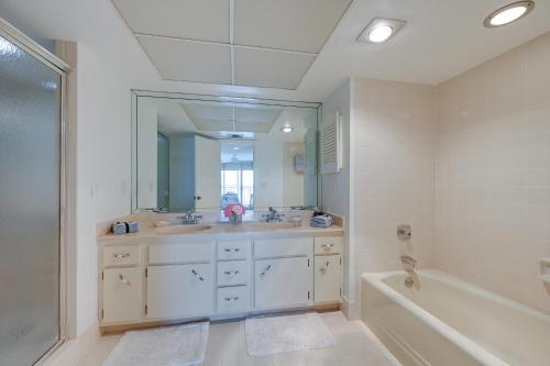 a bathroom with two sinks and a tub and a mirror at Marco Island Condo with Ocean Views and Resort Perks! in Marco Island