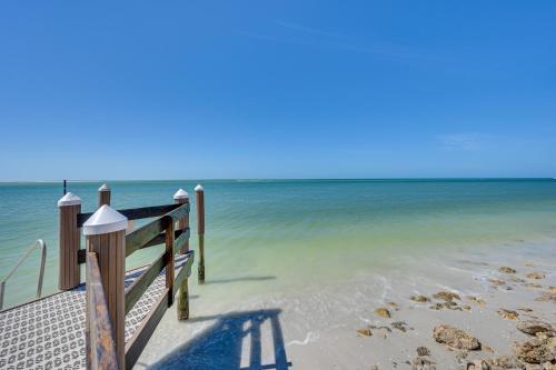 a dock on a beach with the ocean at Marco Island Condo with Ocean Views and Resort Perks! in Marco Island