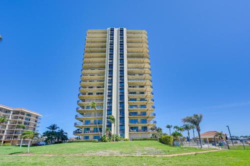 a tallominium building with a grassy area in front of it at Marco Island Condo with Ocean Views and Resort Perks! in Marco Island