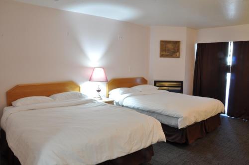 ein Hotelzimmer mit 2 Betten und einem Fenster in der Unterkunft Canadas Best Value Inn Mile-0-Motel Lillooet in Lillooet