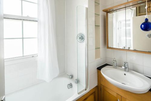 a bathroom with a tub and a sink and a shower at Stylish Central London Flat Near Tower Bridge in London