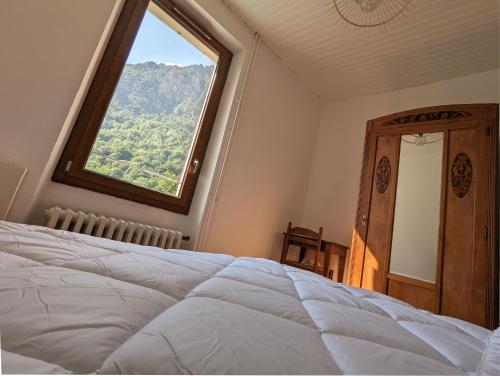 sypialnia z dużym oknem i łóżkiem w obiekcie Gîte Loubet w mieście Saint-Jacques-en-Valgodemard