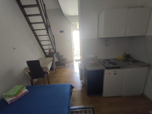 Pokój z kuchnią, stołem i schodami w obiekcie Apartments Berbić w Szybeniku