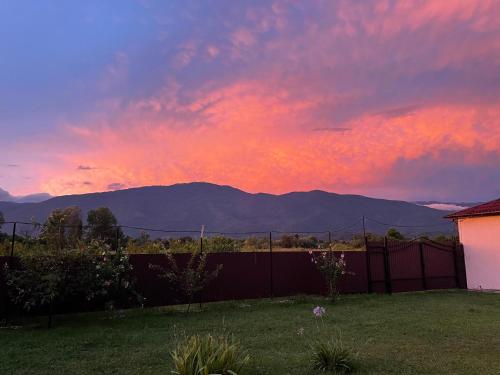 a sunset over a yard with a fence and mountains at Hotel Askar in Alakhadzi