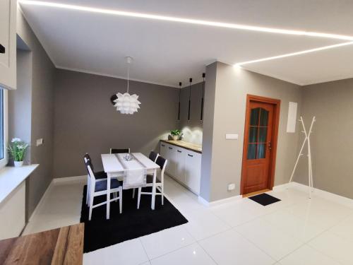 a kitchen and dining room with a table and chairs at Apartamenty Kotarz Sauna&Relaks in Brenna