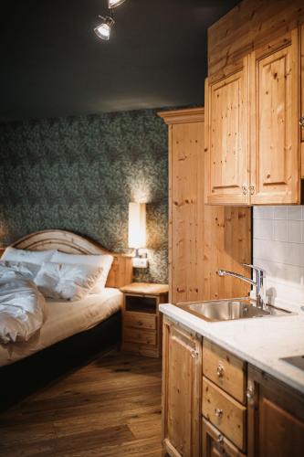 a kitchen with a bed and a sink in a room at Nancy's Holiday Homes Dolomites in Rasùn di Sotto