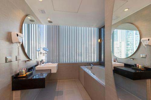 a bathroom with two sinks and a tub and a mirror at Best Western Premier Marina Las Condes in Santiago