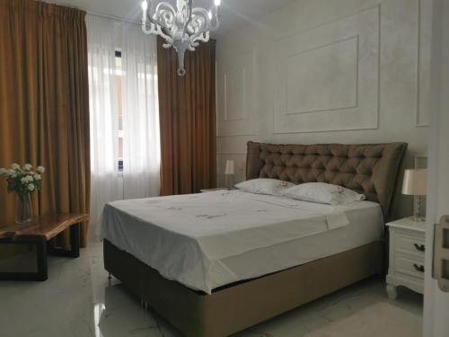 a bedroom with a large bed and a chandelier at The Nest in Năvodari