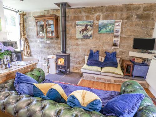 a living room with a couch and a fireplace at Daffodil Cottage in Danby