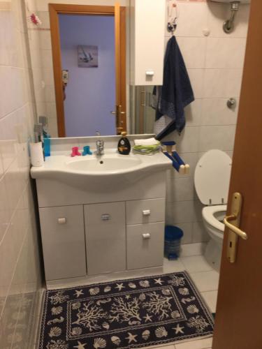 a bathroom with a sink and a toilet and a mirror at Casa Stella Marina in Anzio