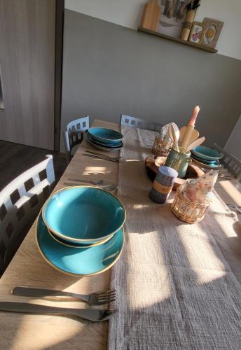 una mesa de madera con placas azules y utensilios. en Under The Castle, en Dob